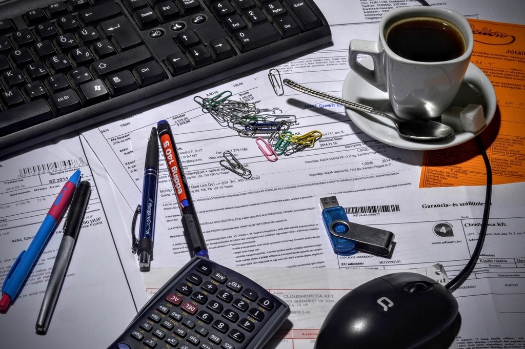 A lawyer's desk with an open invoice, a coffee, and a phone mid-call