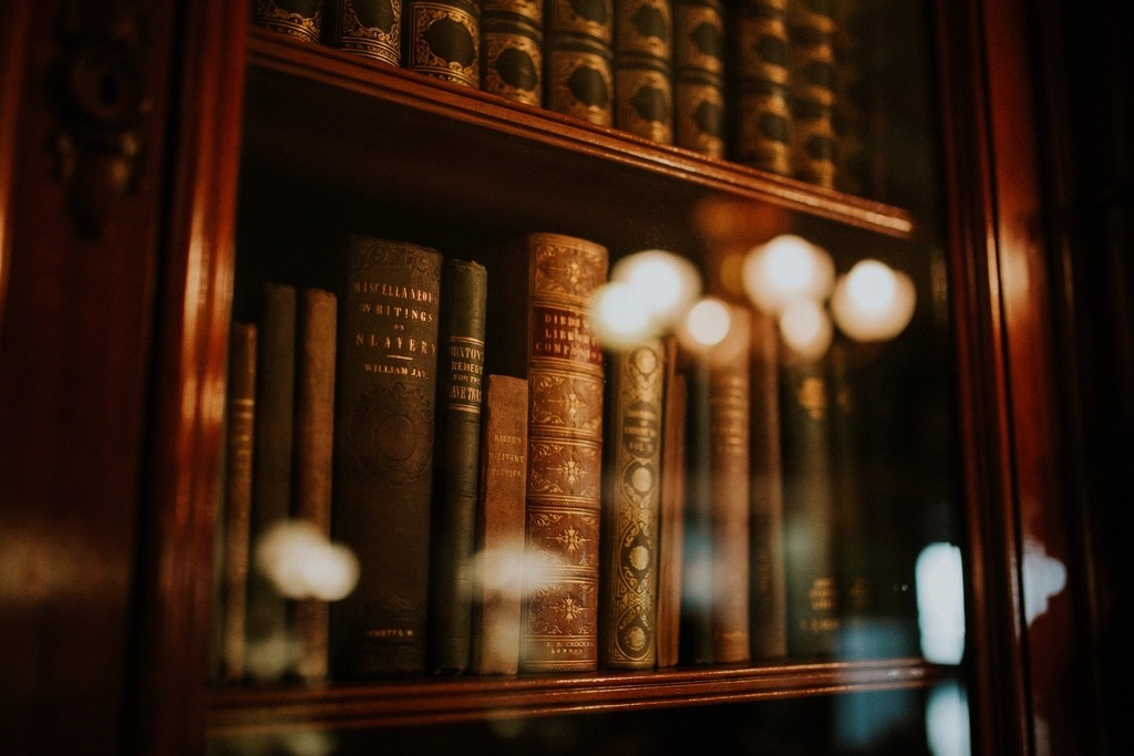 Stack of legal reference books beside a notepad on a boardroom table